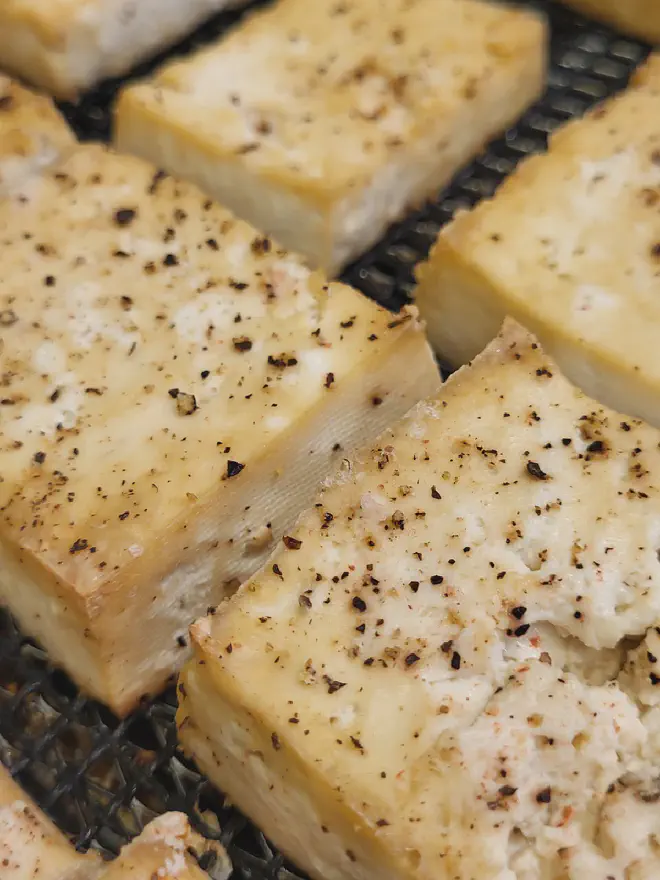 Simple baked tofu on an air fryer basket.